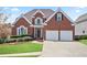 Charming red brick home with a well-maintained lawn, landscaping, and a two-car garage at 4093 Tritt Homestead Dr, Marietta, GA 30062