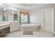 Main bathroom featuring soaking tub with tile surround, double vanity, and natural light at 4093 Tritt Homestead Dr, Marietta, GA 30062