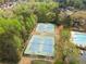 Aerial view of community tennis courts and pool amidst mature trees and green landscape at 4093 Tritt Homestead Dr, Marietta, GA 30062