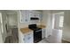 Efficient kitchen with gray cabinets, black appliances, and laminate flooring at 890 Shiloh Ridge Nw Run, Kennesaw, GA 30144