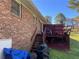 Backyard brick home featuring a wooden deck with stairs, and surrounding vegetation at 1511 Stonewood Dr, Norcross, GA 30093