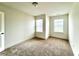 Cozy bedroom featuring carpet flooring and natural light from two windows at 421 Auburn Valley Way, Auburn, GA 30011