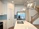 Open kitchen with stainless steel appliances, quartz countertops, and contemporary pendant lighting at 421 Auburn Valley Way, Auburn, GA 30011