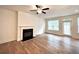 Bright living room with hardwood floors, a fireplace, and a ceiling fan at 421 Auburn Valley Way, Auburn, GA 30011
