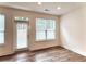 Bright living room with hardwood floors features a window and glass door for natural light at 421 Auburn Valley Way, Auburn, GA 30011