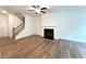 Open concept living room with stairs, fireplace, hardwood floors, and a ceiling fan at 421 Auburn Valley Way, Auburn, GA 30011