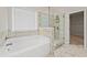 Bright bathroom showcasing a soaking tub, frameless glass shower, and tiled surround at 4229 Brookmont Way, Auburn, GA 30011