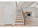 Inviting staircase with hardwood treads and stone fireplace in a spacious living area with coffered ceiling at 4229 Brookmont Way, Auburn, GA 30011