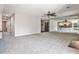 Spacious living room with gray carpet, ceiling fan, and mirrored wall reflecting the kitchen at 68 Hampshire Ct, Avondale Estates, GA 30002