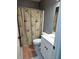 Small bathroom with a floral shower curtain, white sink vanity, and white tiled floor at 2669 Ambria Dr, Buford, GA 30519