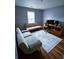 Bedroom with neutral walls and carpet, has grey futon sofa and dark brown desk set at 2669 Ambria Dr, Buford, GA 30519