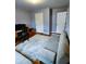Bedroom with neutral walls and carpet, has grey futon sofa and dark brown desk set at 2669 Ambria Dr, Buford, GA 30519