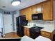 Cozy kitchen featuring wooden cabinetry, black appliances, and tiled backsplash, offering a functional cooking space at 2669 Ambria Dr, Buford, GA 30519