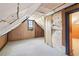 Spacious attic featuring carpeted flooring, wood paneled walls, and a window providing natural light at 28 Exeter Rd, Avondale Estates, GA 30002