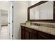Bathroom with a dark wood vanity and granite countertop, decorative mirror, and tile flooring at 2875 Waterstone Dr, Cumming, GA 30041