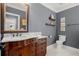 A charming bathroom features a wood vanity with granite countertop, toilet, and decorative shelves at 2875 Waterstone Dr, Cumming, GA 30041