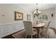 Cozy dining area with a chandelier, classic wainscoting, and large window overlooking the backyard at 2875 Waterstone Dr, Cumming, GA 30041