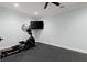 A home gym with an elliptical machine, mounted TV, rubber flooring, and ample space for workouts at 2875 Waterstone Dr, Cumming, GA 30041