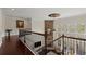 Hallway featuring hardwood floors, modern railing, and stone accent wall with fireplace at 2875 Waterstone Dr, Cumming, GA 30041