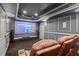 A home theater room featuring plush seating, a large screen, and elegant wall sconces for an immersive experience at 2875 Waterstone Dr, Cumming, GA 30041
