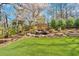 Beautiful backyard featuring an artificial lawn and a custom-built rock waterfall surrounded by manicured landscaping at 3509 Ivy Manor Se Rd, Smyrna, GA 30080