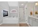Bright bathroom featuring a soaking tub, glass shower, and decorative tile accents at 3509 Ivy Manor Se Rd, Smyrna, GA 30080