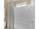 Clean bathroom with white tiled walls, a shower and tub combination, and neutral-toned curtain for added privacy at 3509 Ivy Manor Se Rd, Smyrna, GA 30080
