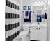 Well-lit bathroom featuring black and white striped shower curtain and white vanity at 3509 Ivy Manor Se Rd, Smyrna, GA 30080