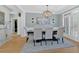 Formal dining room with elegant chandelier, wainscoting, and large windows for abundant natural light at 3509 Ivy Manor Se Rd, Smyrna, GA 30080