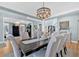 Formal dining room with elegant chandelier, wainscoting, and large windows for abundant natural light at 3509 Ivy Manor Se Rd, Smyrna, GA 30080