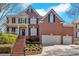 Beautiful two-story red brick home with a well-manicured lawn, two-car garage, and inviting entrance at 3509 Ivy Manor Se Rd, Smyrna, GA 30080