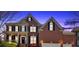 Beautiful brick home with a well-manicured lawn and classic architectural details at twilight at 3509 Ivy Manor Se Rd, Smyrna, GA 30080