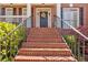 Welcoming front entrance with a brick staircase, black door with wreath, and manicured landscaping at 3509 Ivy Manor Se Rd, Smyrna, GA 30080