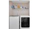 Well-lit laundry room featuring modern washer and dryer units, and shelving for organizing cleaning supplies at 3509 Ivy Manor Se Rd, Smyrna, GA 30080