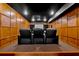 Home theater with tiered seating, wood paneling, and projector screen at 3509 Ivy Manor Se Rd, Smyrna, GA 30080