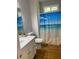 Bright bathroom features a vanity with a white countertop and beach-themed shower curtain at 4748 Arcado Sw Rd, Lilburn, GA 30047