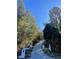 Long concrete driveway flanked by landscaping and trees at 4748 Arcado Sw Rd, Lilburn, GA 30047