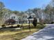 Elegant two-story white brick home with mature trees and manicured lawn on a sunny day at 4748 Arcado Sw Rd, Lilburn, GA 30047
