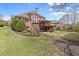 Expansive backyard featuring a stone fireplace, outdoor deck, and lush green lawn at 1060 Meadow Brook Dr, Woodstock, GA 30188
