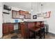 Basement wet bar with rich wood cabinetry, granite countertop, overhead lighting, and seating for three at 1060 Meadow Brook Dr, Woodstock, GA 30188