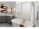 Modern bathroom featuring soaking tub, shutters, and unique shelf accents at 1060 Meadow Brook Dr, Woodstock, GA 30188