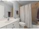 Bathroom featuring a single vanity, toilet, framed mirror and a shower with a neutral shower curtain at 1060 Meadow Brook Dr, Woodstock, GA 30188