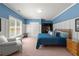 Comfortable bedroom with blue walls, wainscoting, a bright window, and a plush chair for relaxing at 1060 Meadow Brook Dr, Woodstock, GA 30188