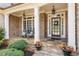 Inviting front porch with stone floor, rocking chairs, and flower pots by the entrance at 1060 Meadow Brook Dr, Woodstock, GA 30188