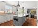 Modern kitchen featuring an island with seating, stainless steel appliances, and backyard views at 1060 Meadow Brook Dr, Woodstock, GA 30188