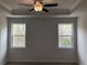 Bedroom with tray ceiling, ceiling fan, carpet, and two windows at 1282 Ainsworth Aly, Sugar Hill, GA 30518