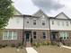 Inviting townhome featuring a brick facade, landscaped yard, and covered entryway at 1282 Ainsworth Aly, Sugar Hill, GA 30518