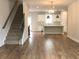 Open floor plan with staircase connects living area and kitchen with granite breakfast bar at 1282 Ainsworth Aly, Sugar Hill, GA 30518
