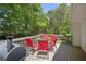 View of the back deck with outdoor seating and a grill, surrounded by lush green trees at 320 Creek Side Ct, Mcdonough, GA 30252