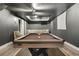 Finished basement with a pool table, seating area, and a drop ceiling at 320 Creek Side Ct, Mcdonough, GA 30252